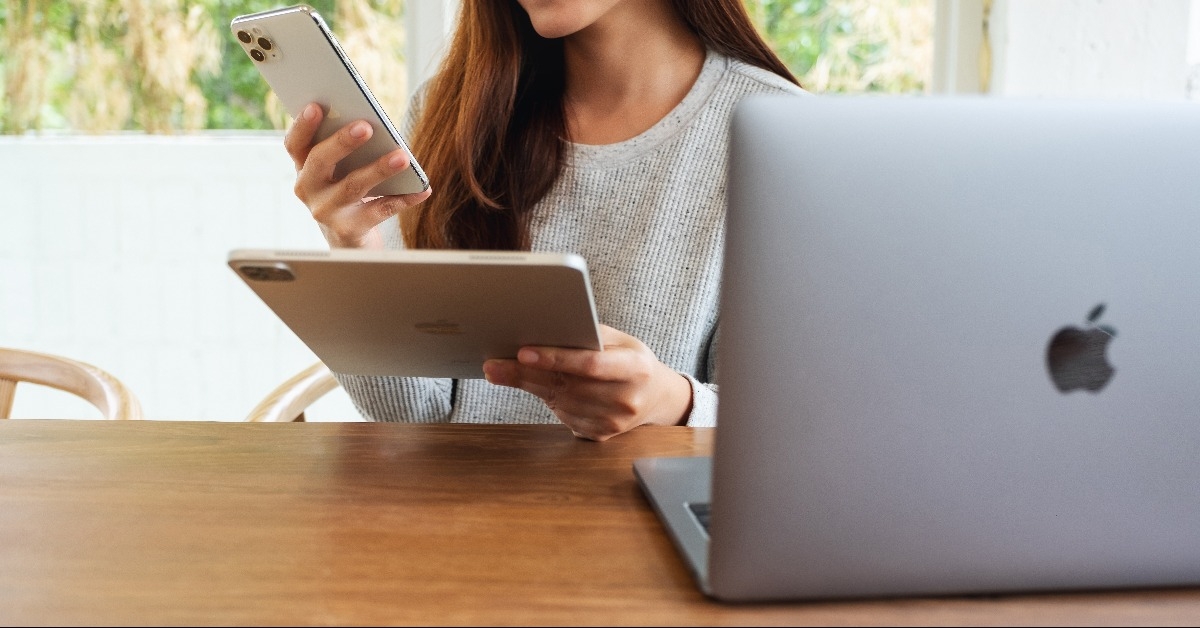 woman holding and using Iphone 11 Pro Max smart phone and Apple New Ipad