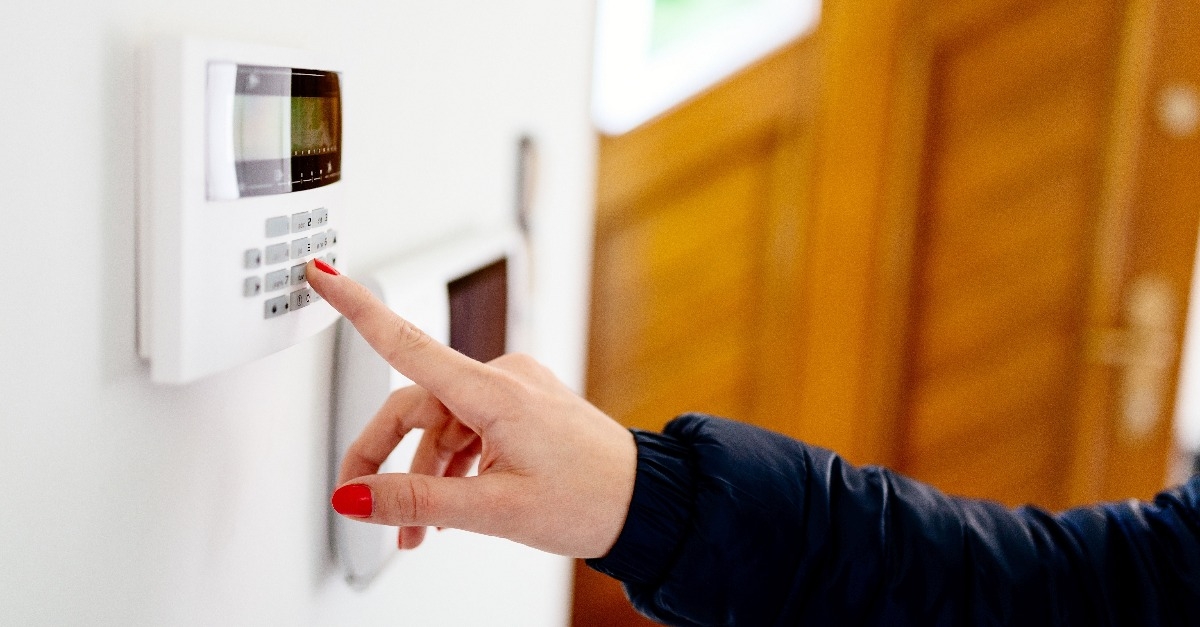 young woman entering security code on keypad