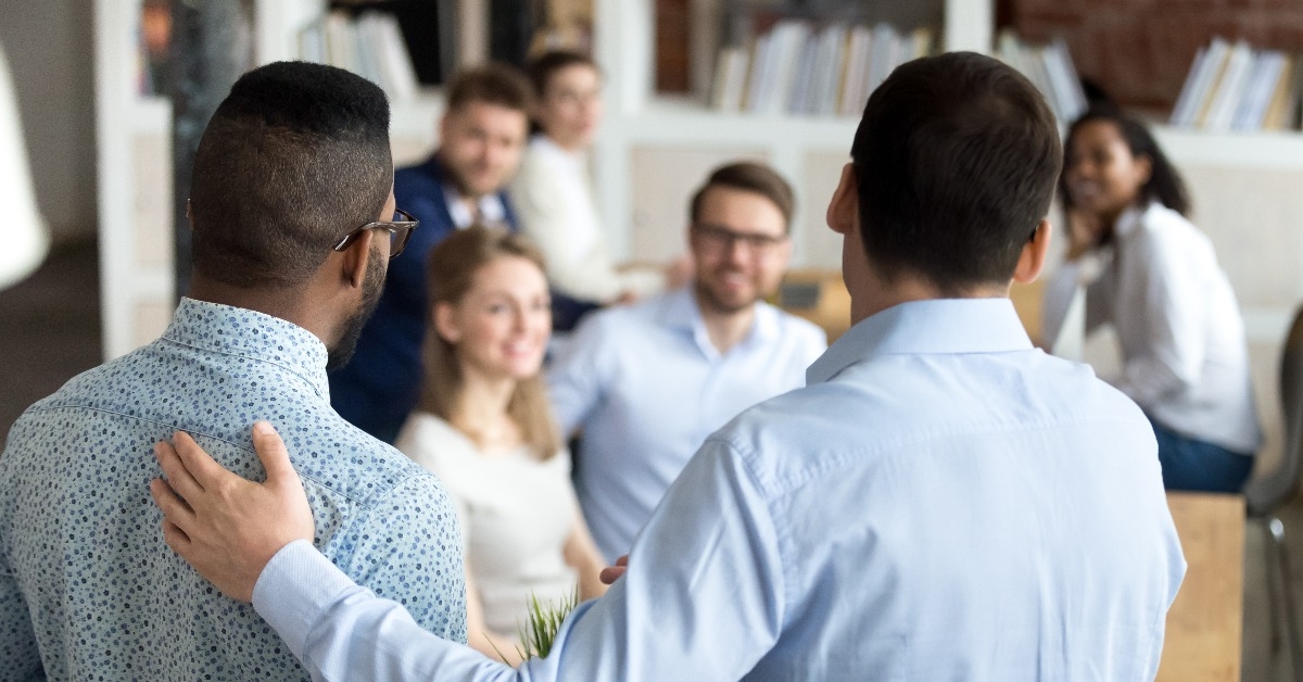 boss introducing black new worker to workmates