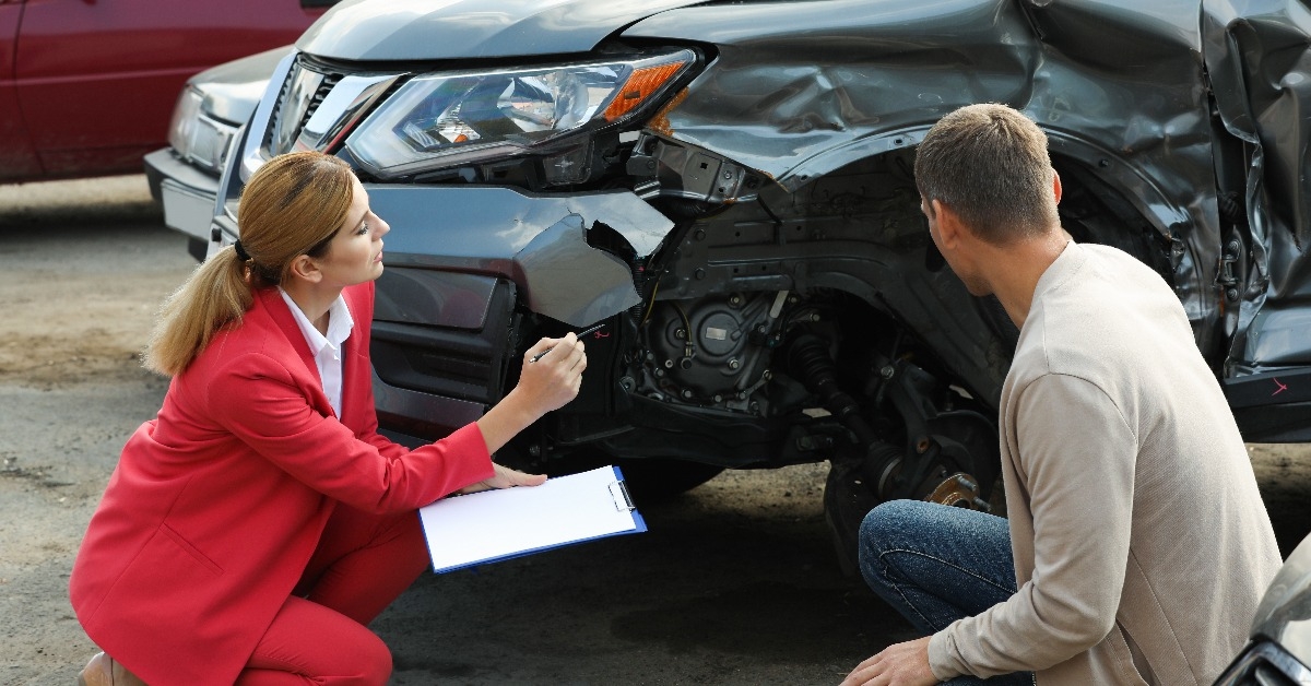 man reporting and insurance agent filling claim form