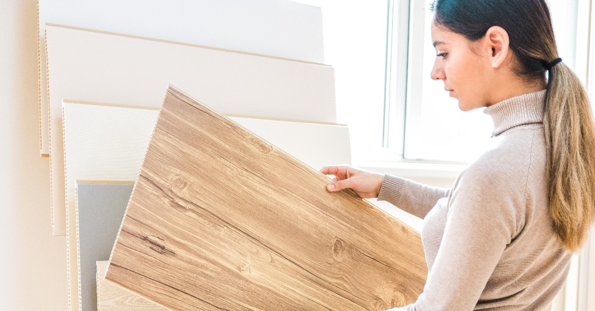 woman choosing wood laminated flooring in shop