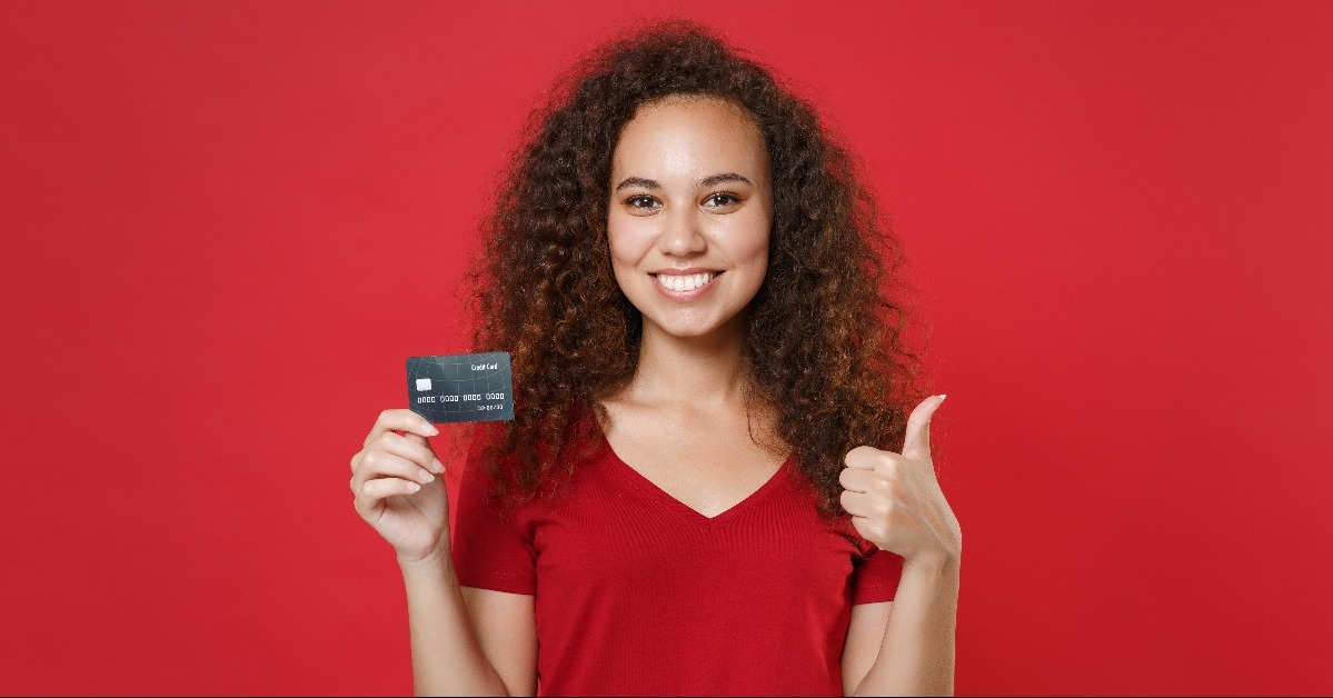 woman in red shirt  holding a credit bank card