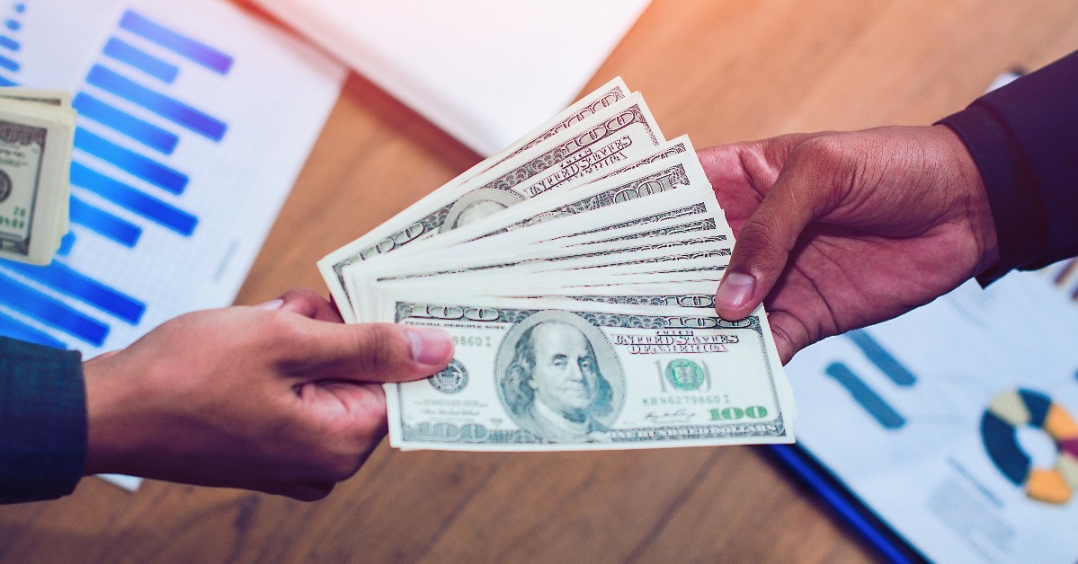 businessman hand giving money to other hand