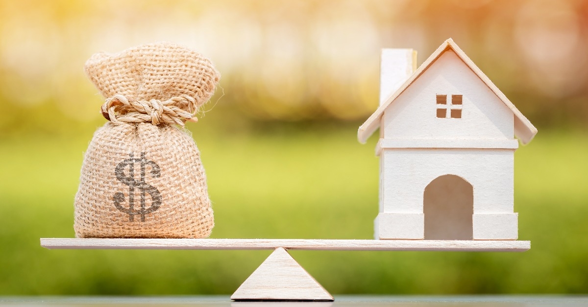 model house and money bag put on the scales with balance
