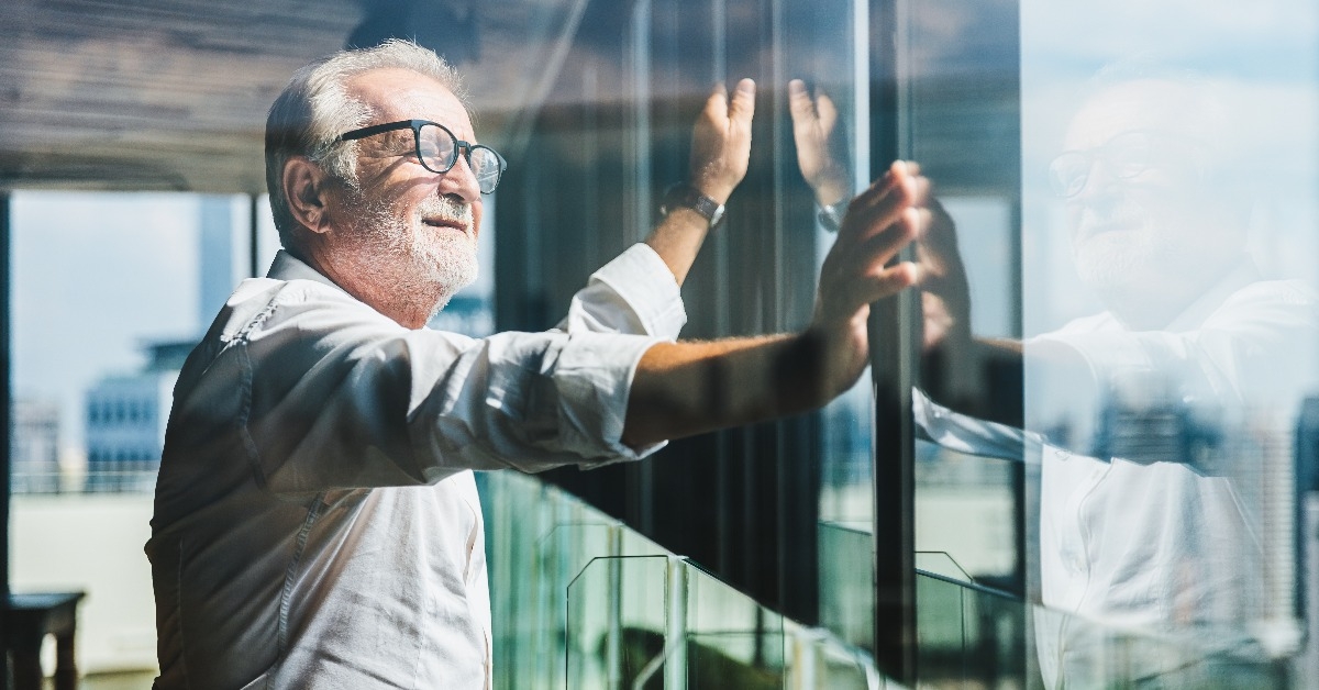 senior grey-haired businessman standing and looking to right hand 