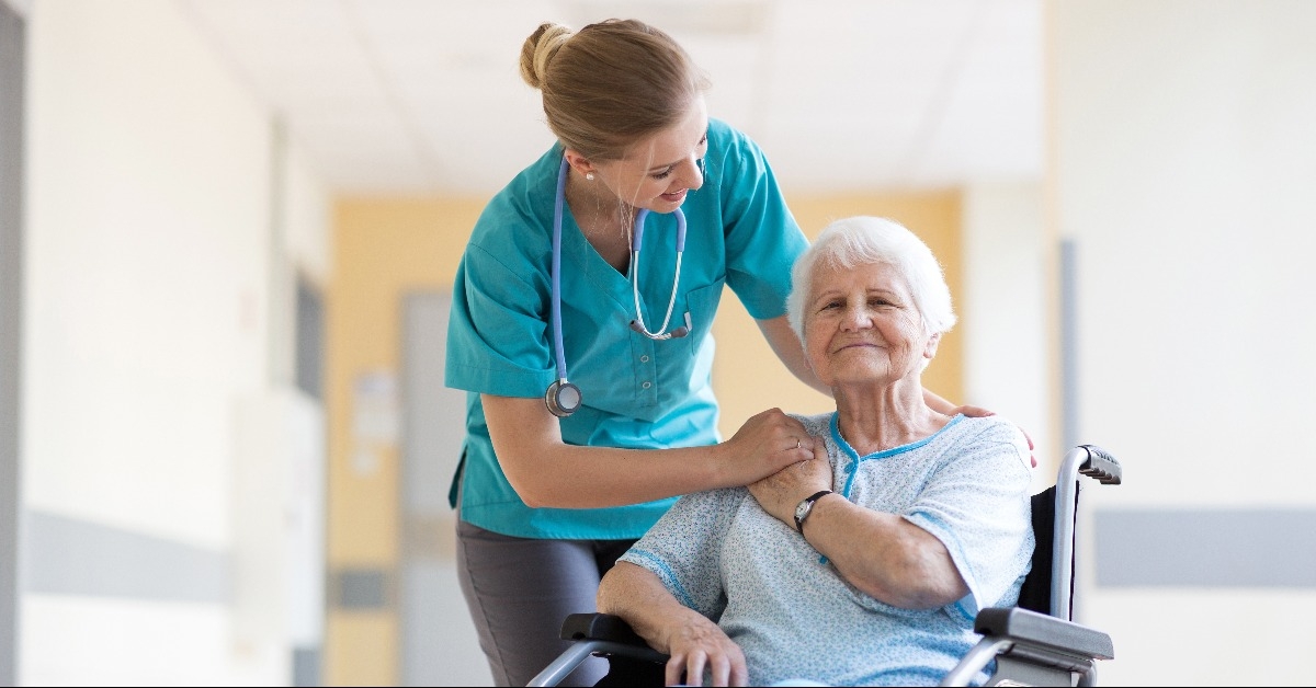 senior woman in wheelchair with nurse in hospital