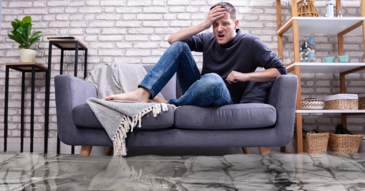 upset man in the room flooded with water