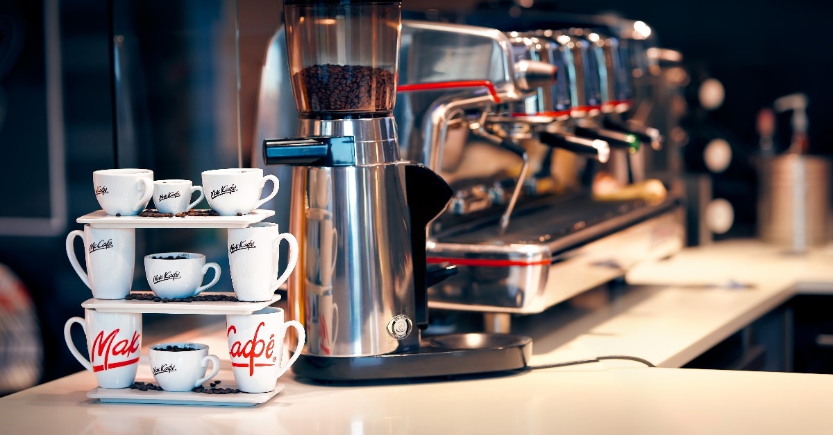 various types of ceramic coffee cups with McCafe logo on stand