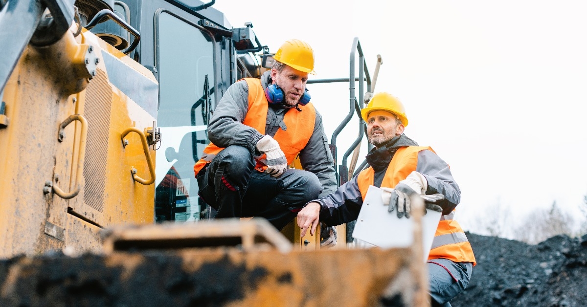 foreman showing worker in open-cast mining pit direction