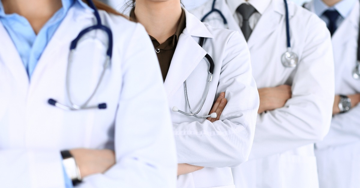 group of modern doctors standing as a team with arms crossed