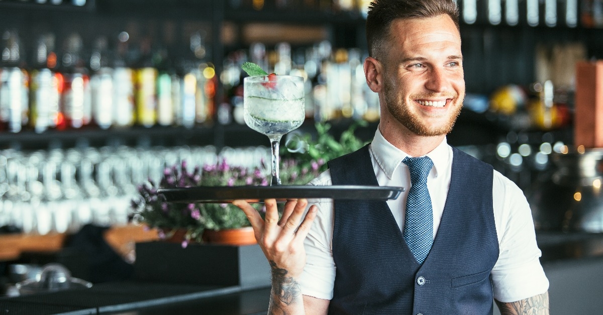 smiling waiter ready to serve a cocktail