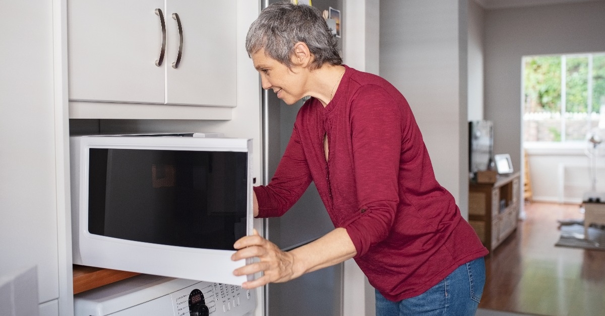 mature woman using microwave oven