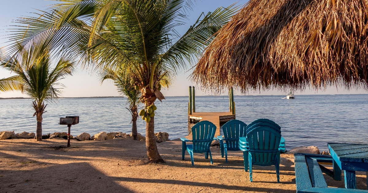 beach chairs and tiki hut on the shore on a beach in Key Largo Florida