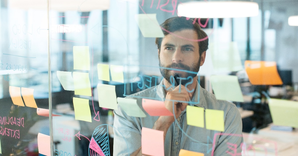  businessman looking at strategy written on glass