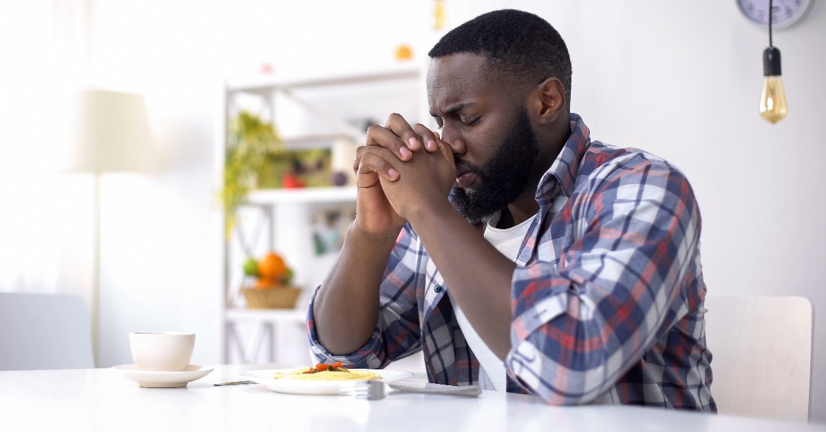 man praying before lunch thanking God for meal