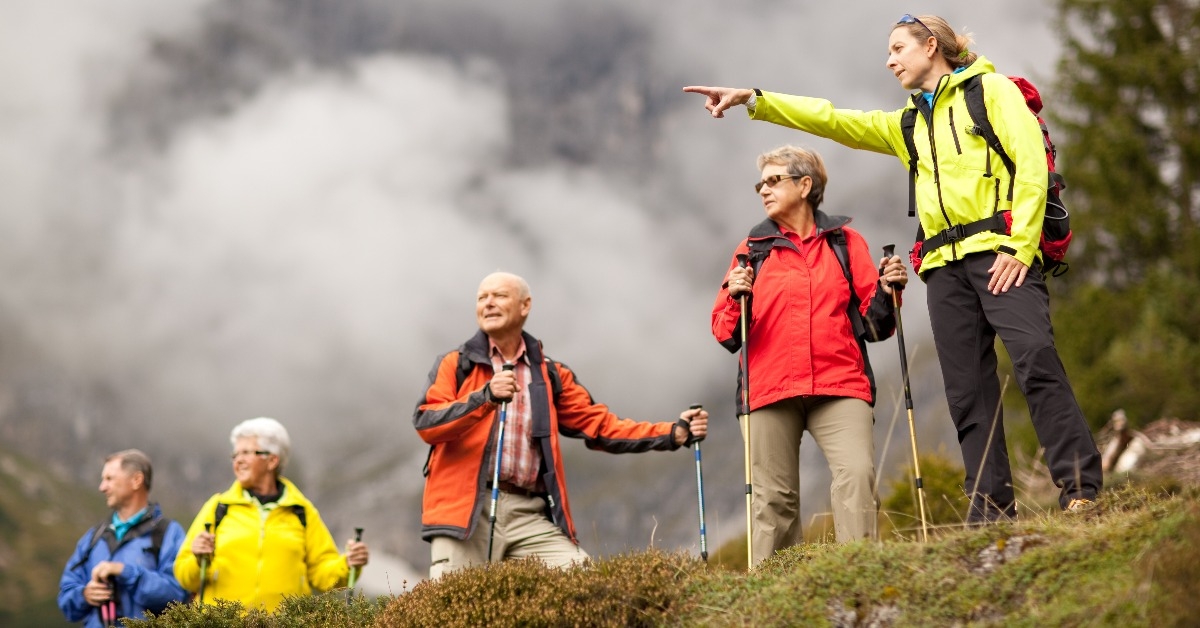 hiking guide showing senior group surrounding mount