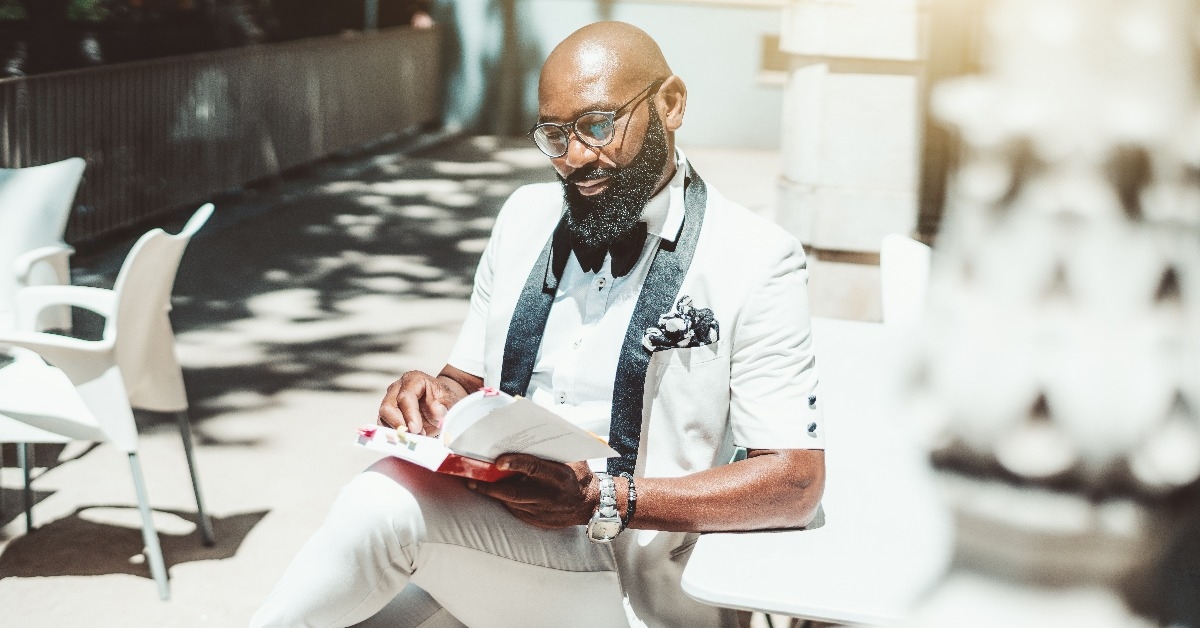 man in eyeglasses and a white elegant suit with a bow-tie