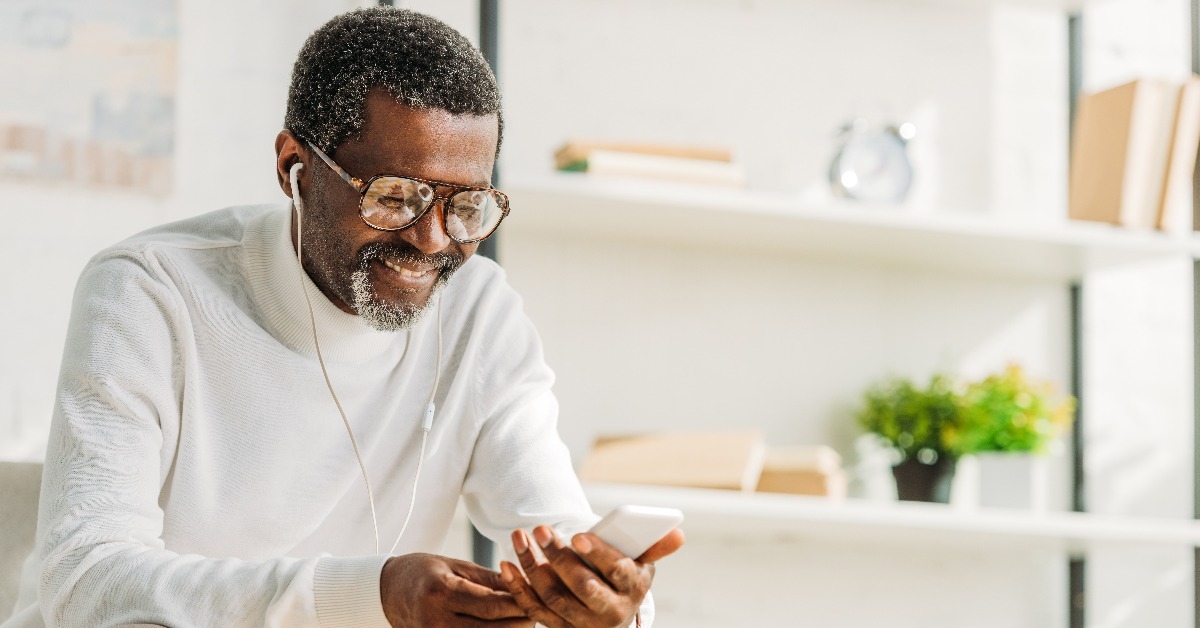man using smartphone while listening music in headphones