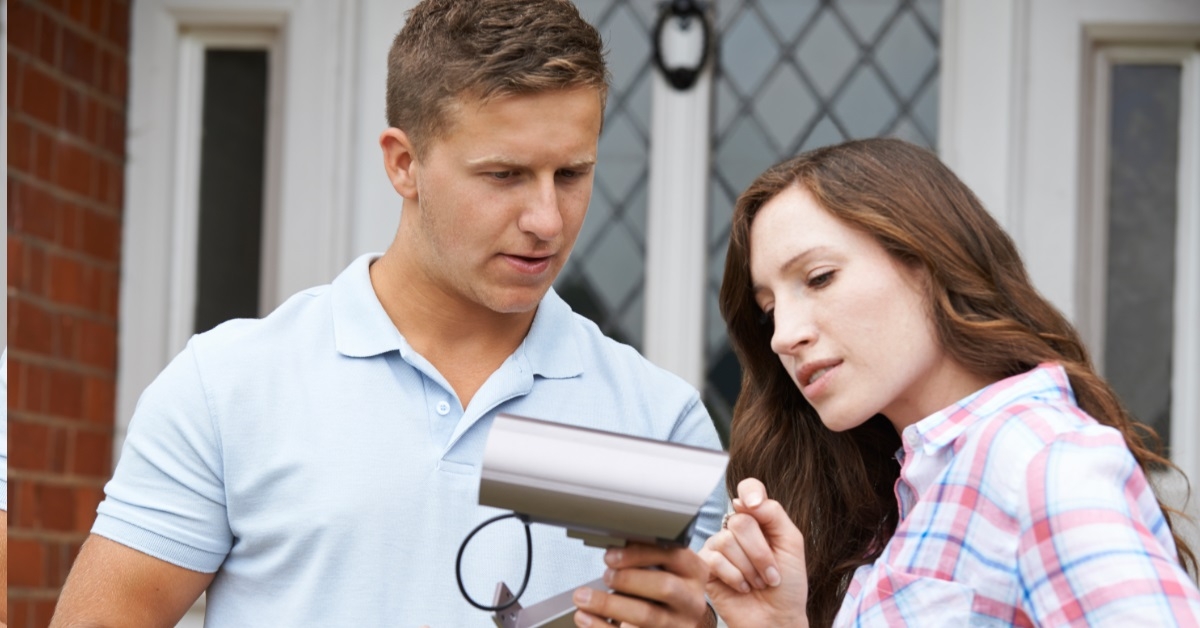 couple holding a cctv camera in hand