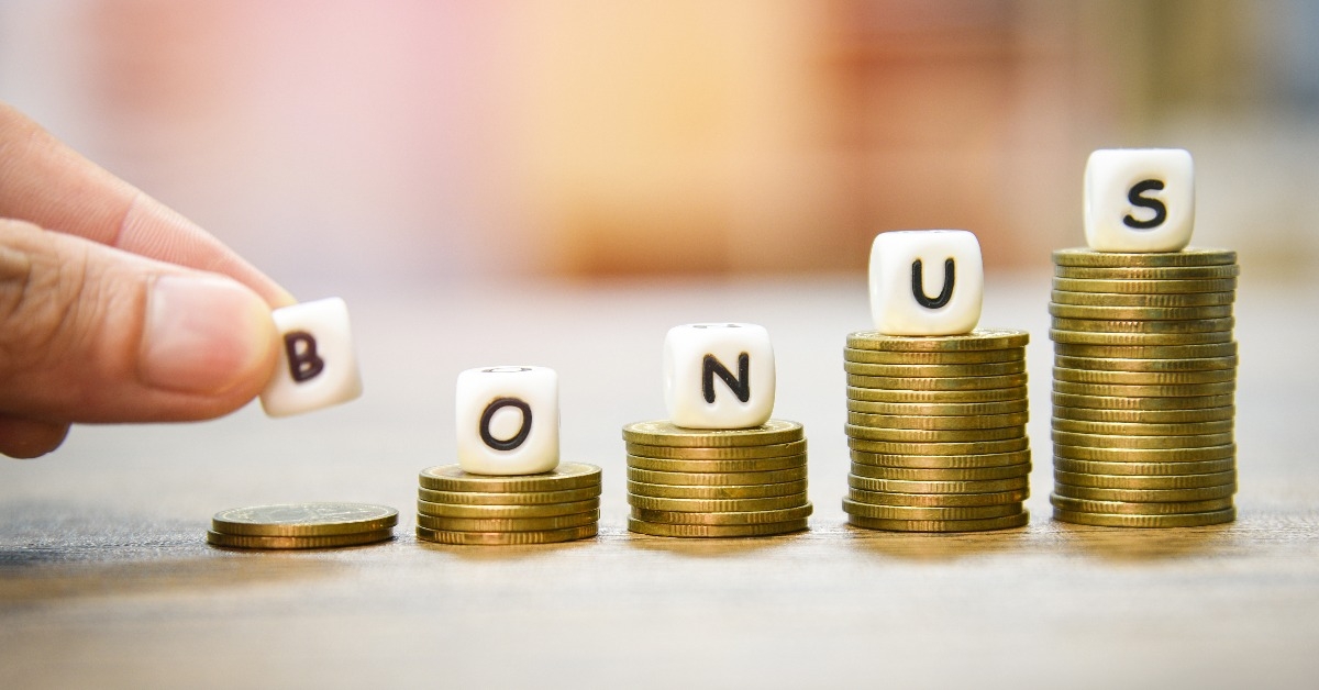 hand holding words of bonus on stack coins staircase