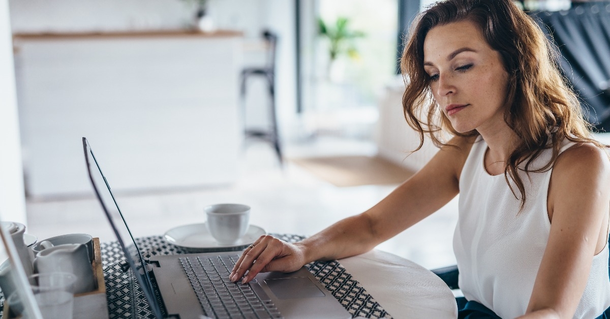 woman using laptop while sitting at table