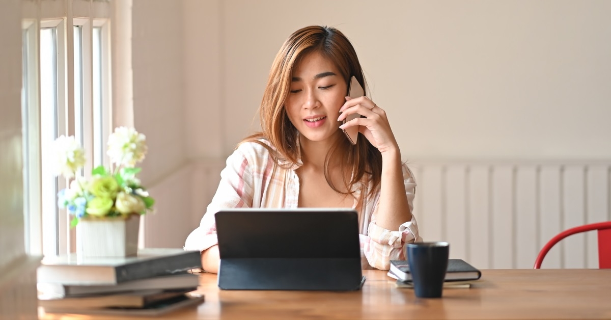 woman using a laptop while on the phone