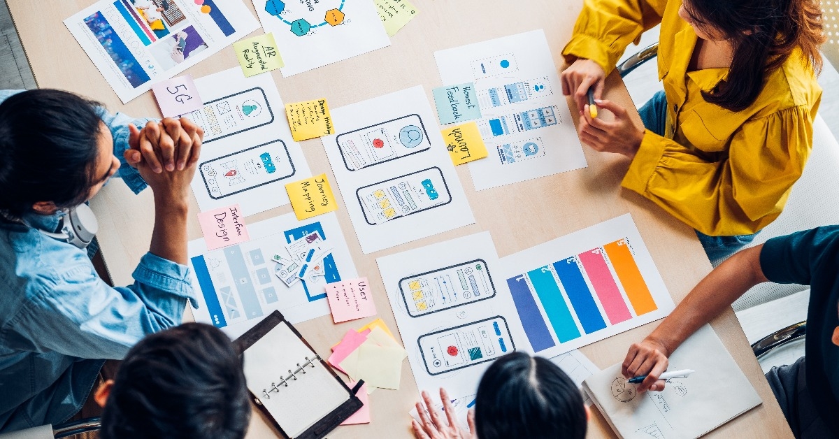  asian UX developer and UI designer brainstorming about mobile app interface