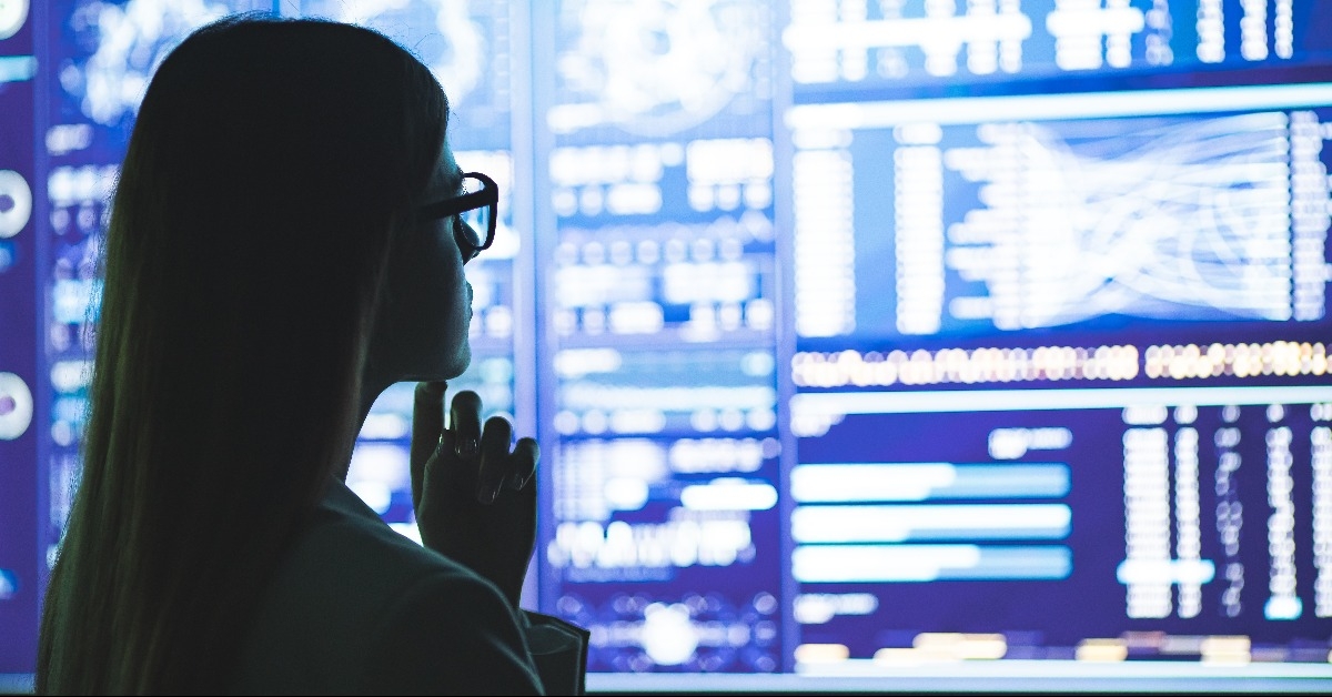 businesswoman standing near the display with graphs