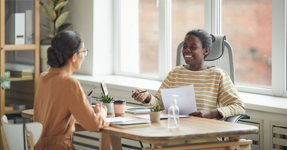 woman talking to young woman across table during job interview