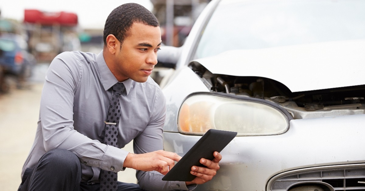 loss adjuster using digital tablet in car wreck inspection