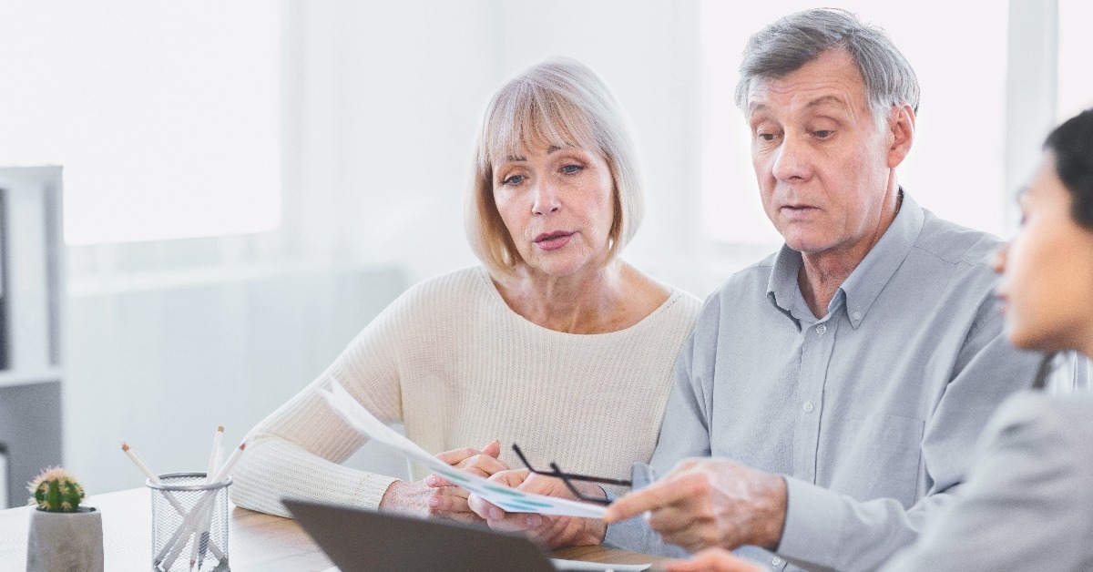 mature couple talking to financial advisor at home