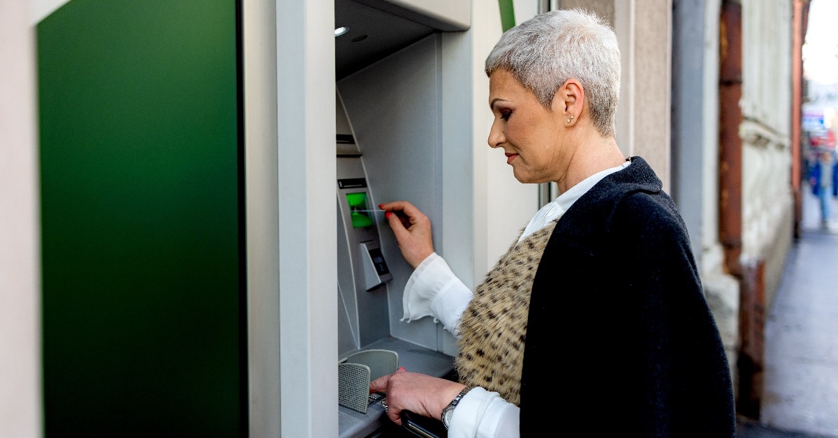 middle age woman is withdrawing money from ATM machine