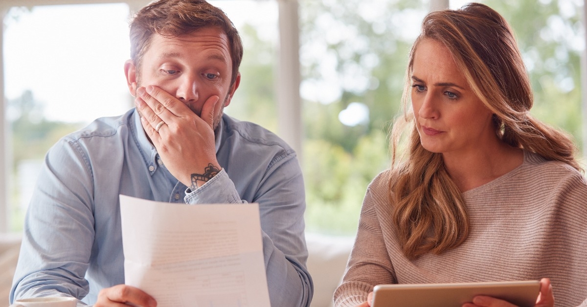 worried couple with bills
