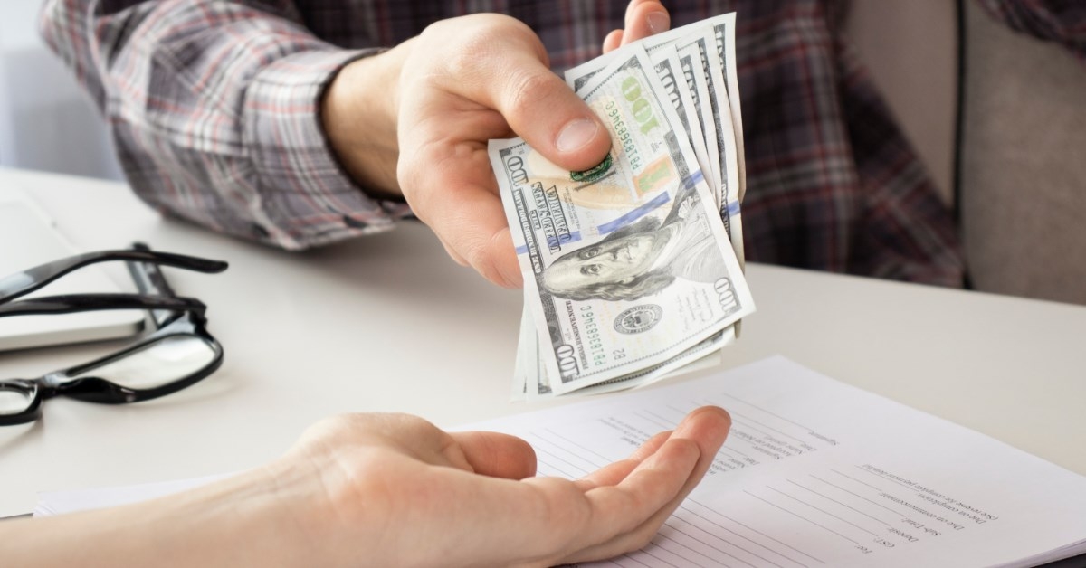 man giving money to another person