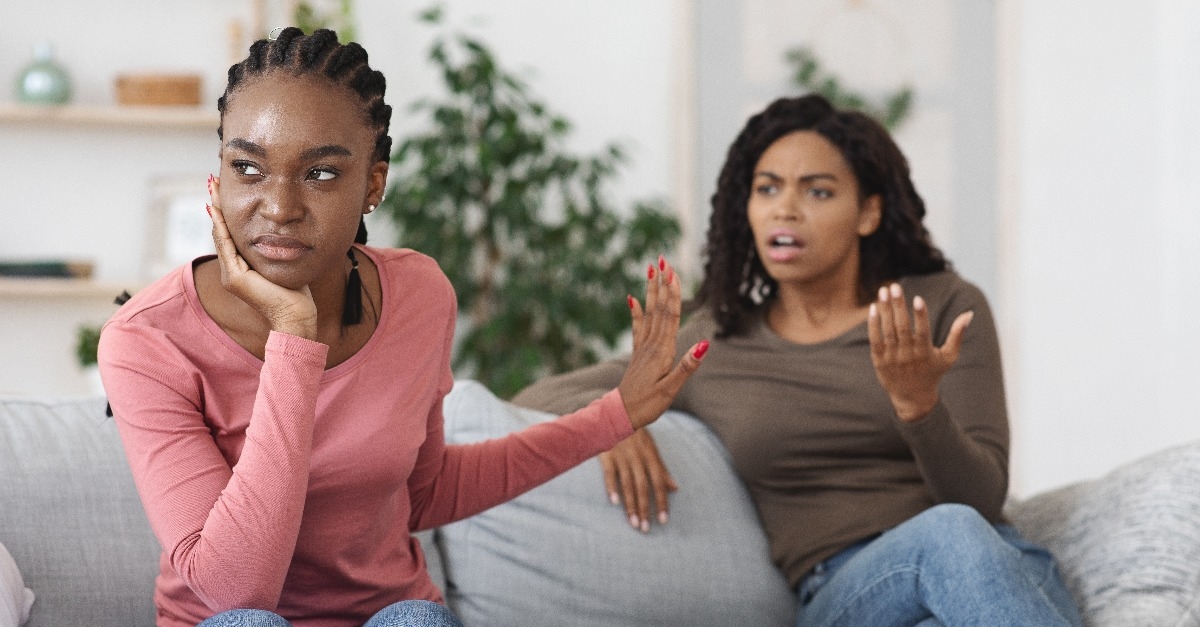 annoyed black woman showing stop gesture to her scolding girlfriend