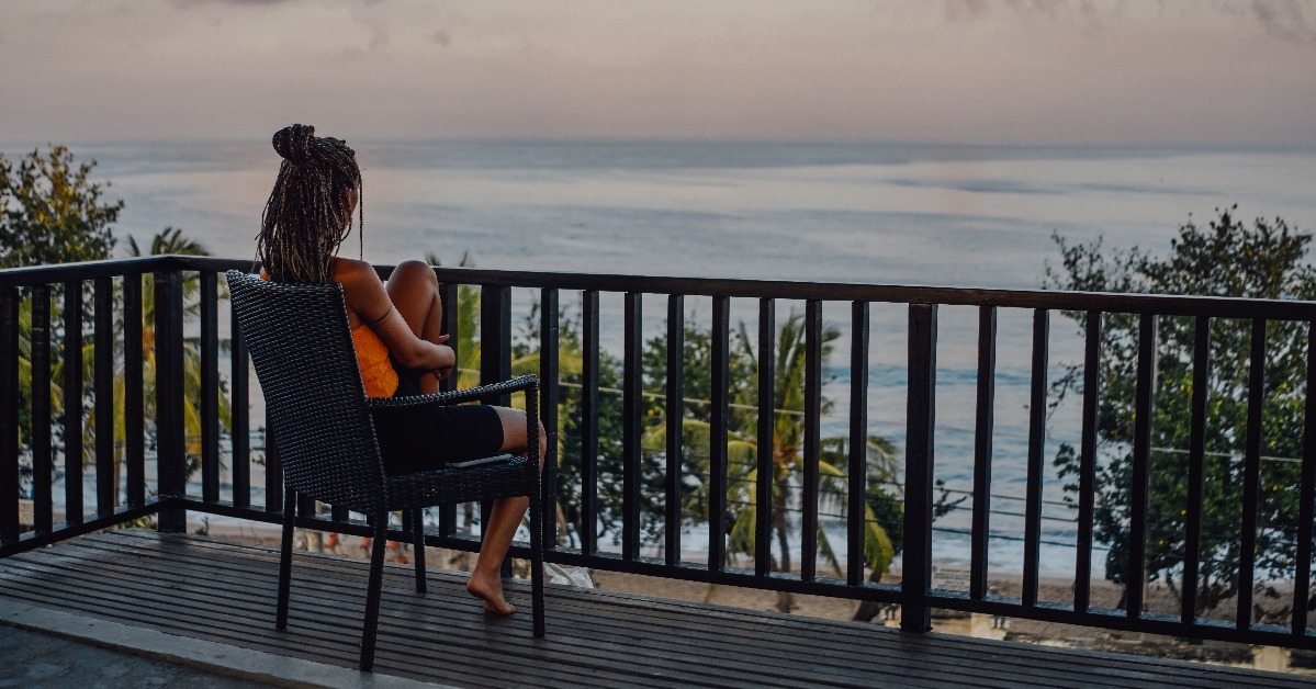 carefree woman sitting on chair against beach landscape