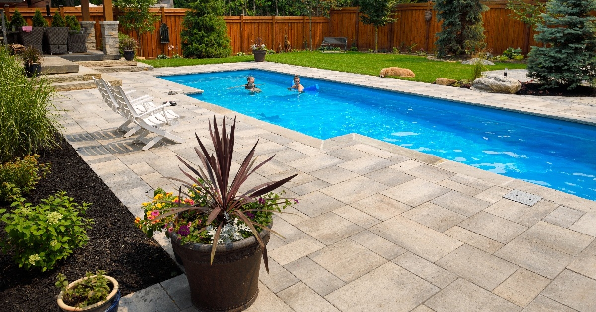 mother and daughter swimming in new back yard pool with dog