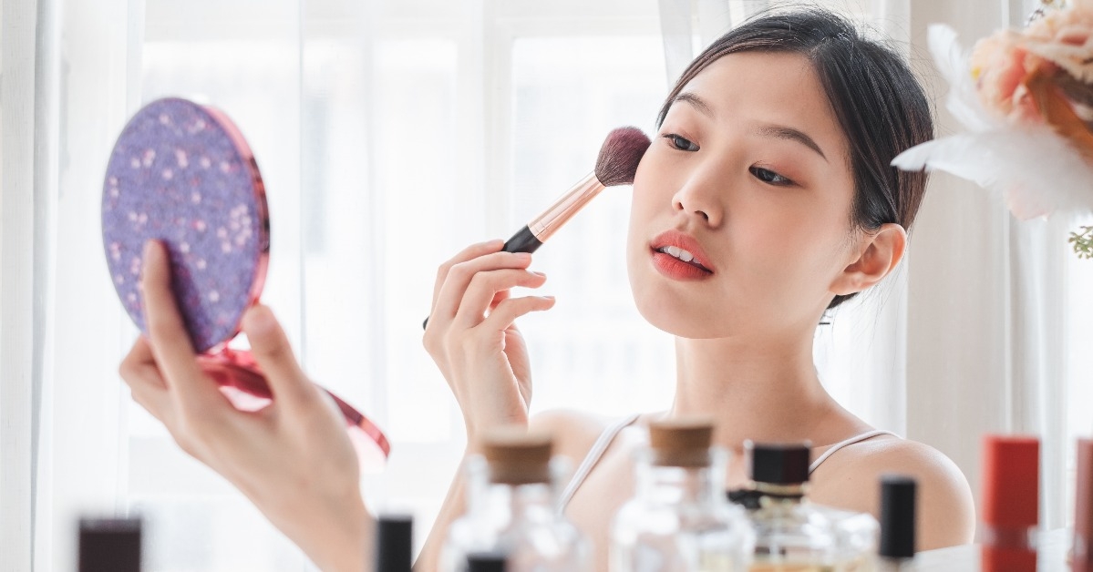 woman applying cosmetics make up on her face