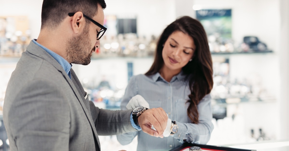 woman holding and showing expensive watch to male buyer