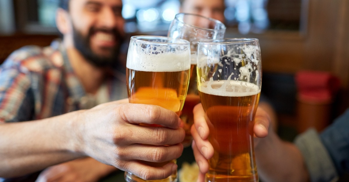 male friends drinking beer at bar or pub