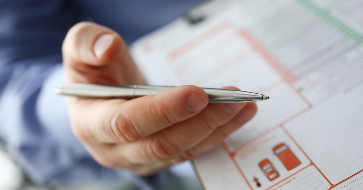 man signing a document with silver pen