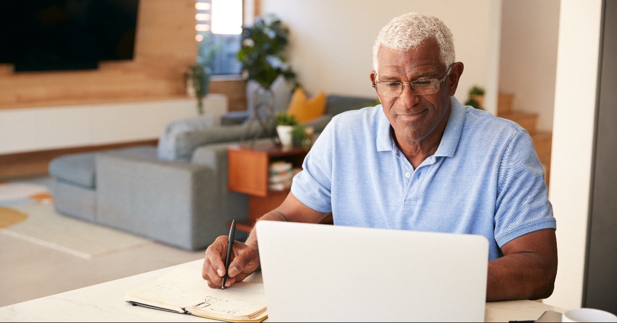 man using laptop to check finances at home