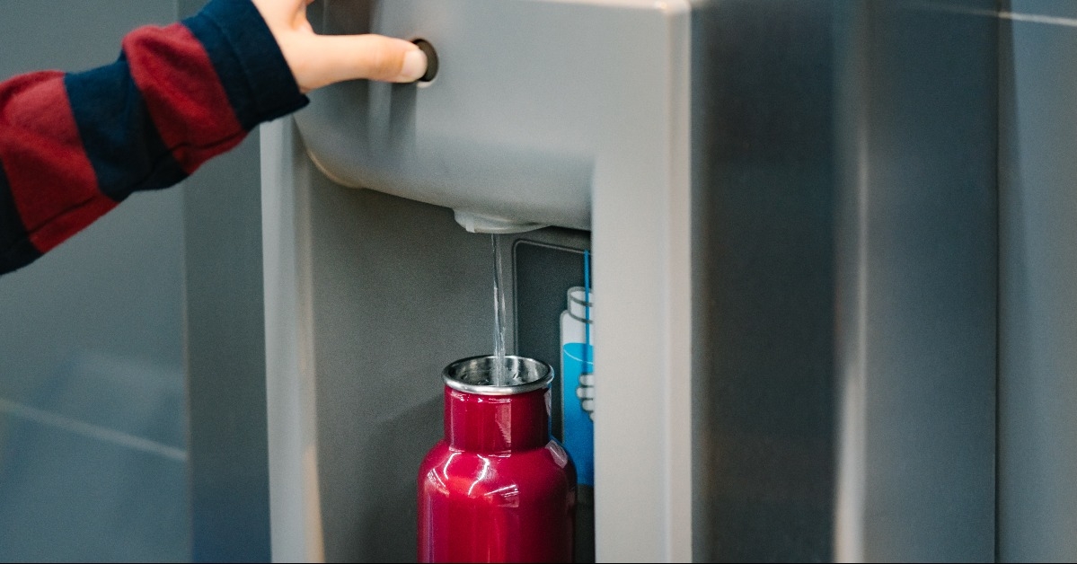 traveler pressed the button of drinking water filling station at the airport