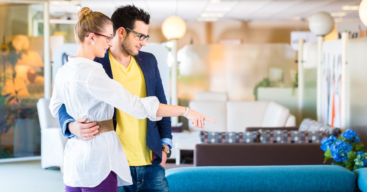 couple buying couch in furniture store