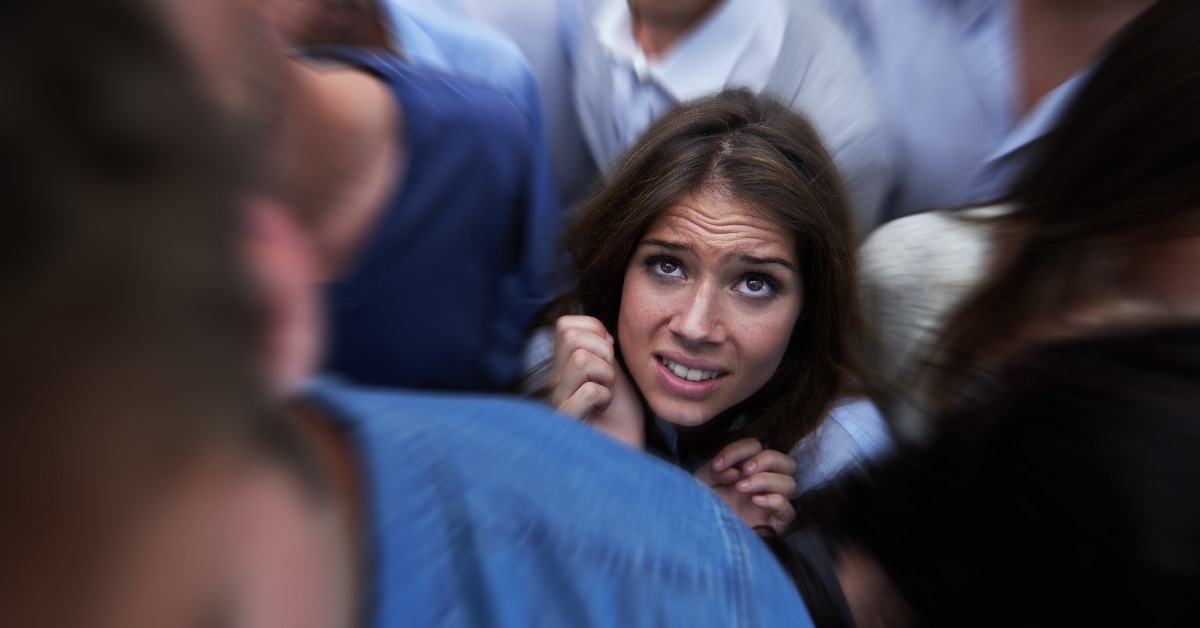  fearful young woman feeling trapped by the crowd