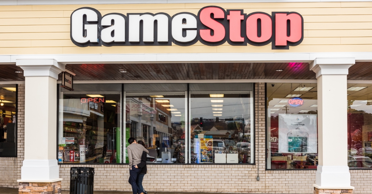 couple passing by a GameStop store