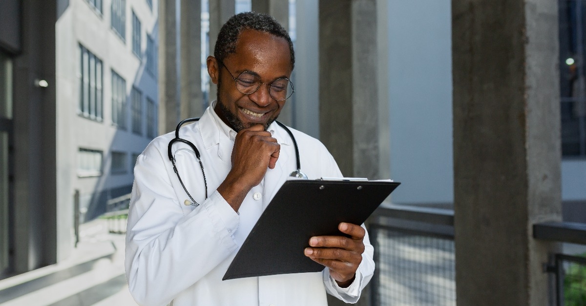 doctor reading report documents outside clinic