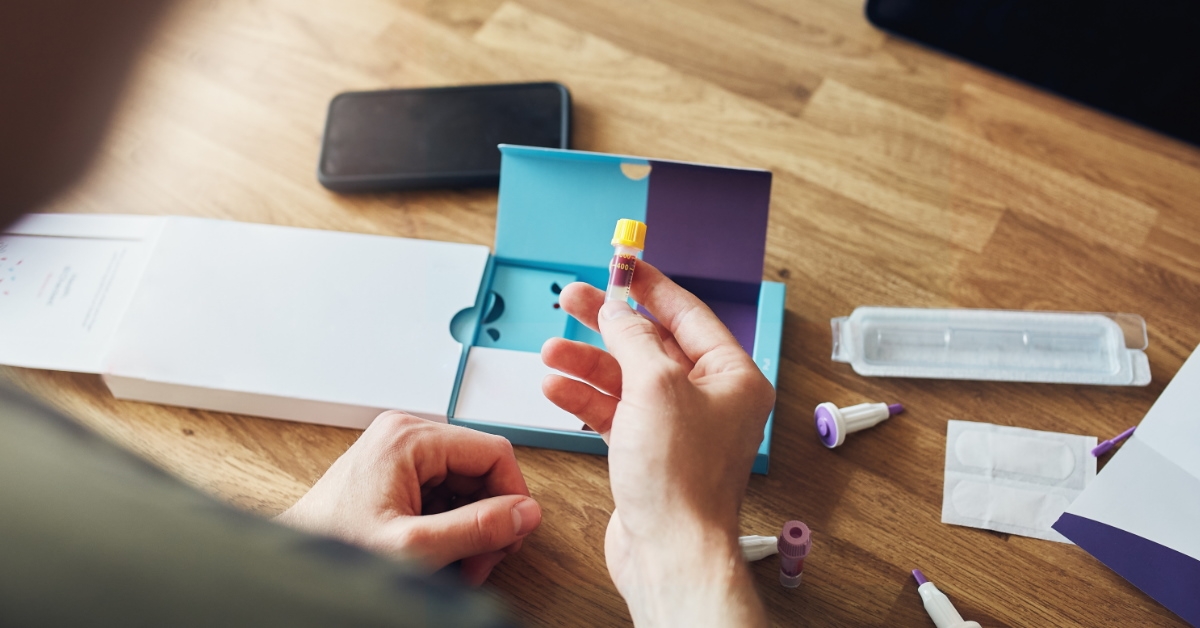 man having a look at a blood sampling kit on a table