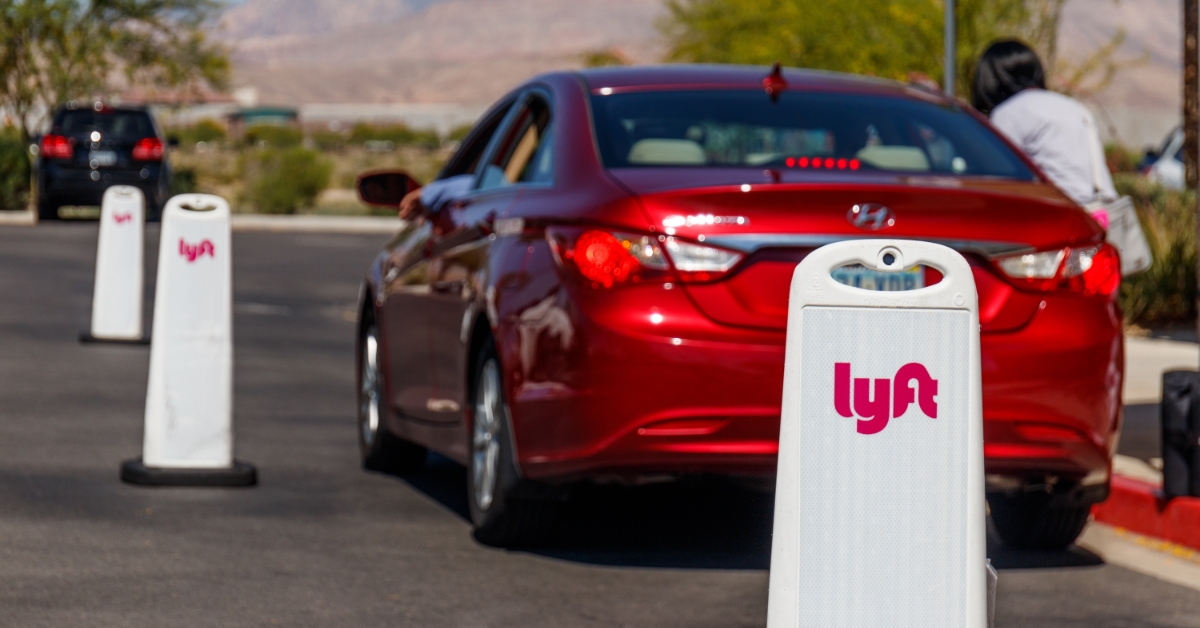 woman sitting in a car with a lot of Lyft banners