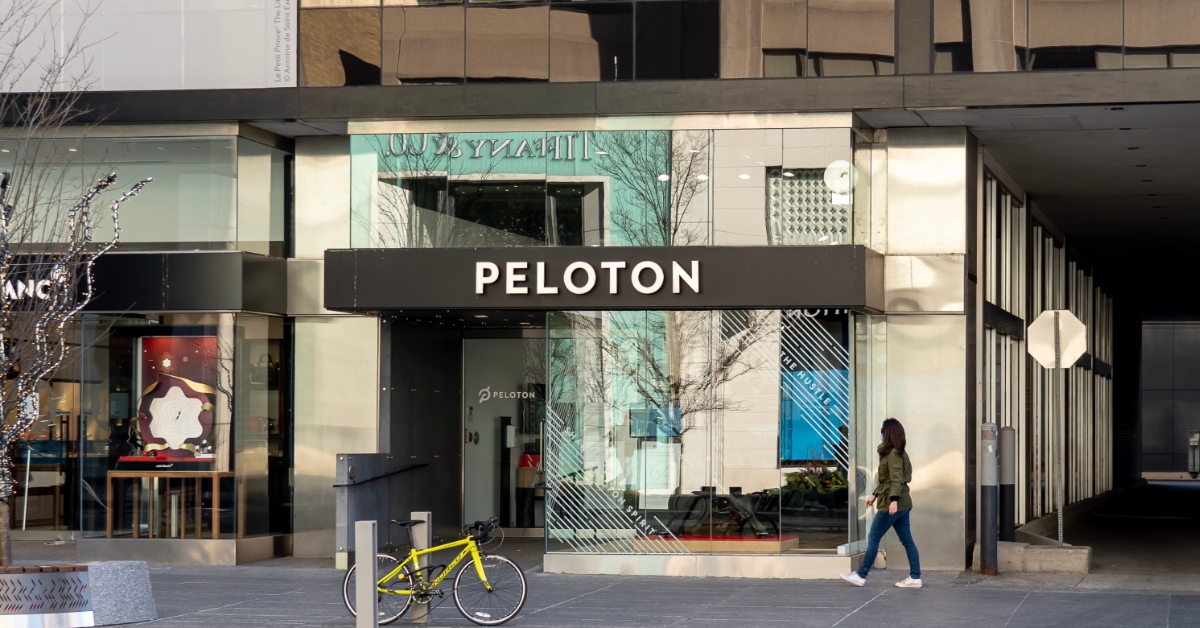 woman walking on the street passing by Peloton store